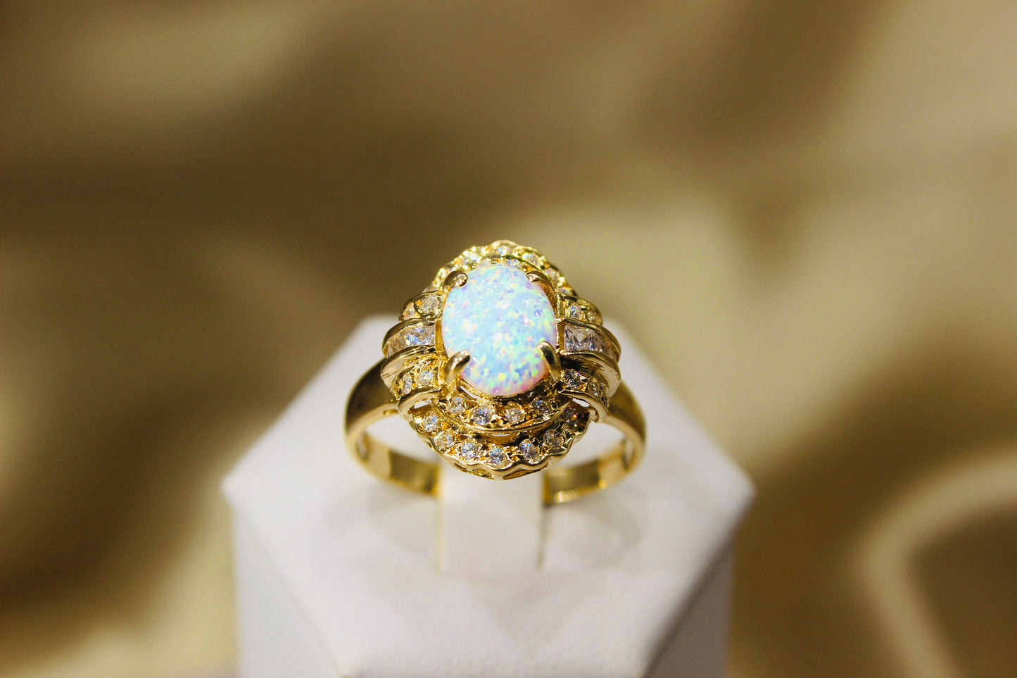 Opal oval in 14K yellow gold surrounded by zirconia stones in 4-claw setting