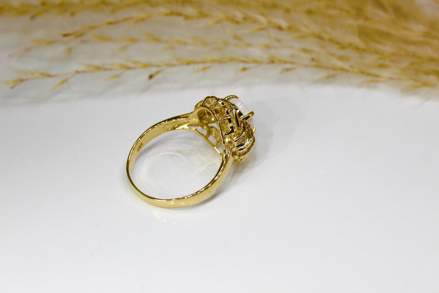 Opal oval in 14K yellow gold surrounded by zirconia stones in 4-claw setting
